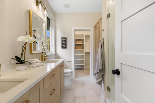 bathroom with a shower with shower door, tile patterned flooring, toilet, and vanity