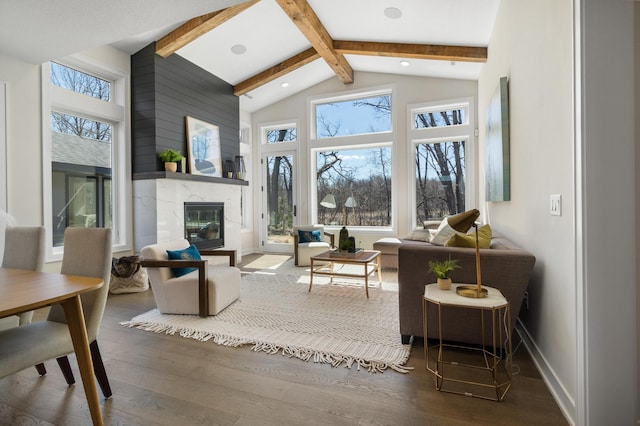 living room featuring a premium fireplace, hardwood / wood-style flooring, beam ceiling, and high vaulted ceiling