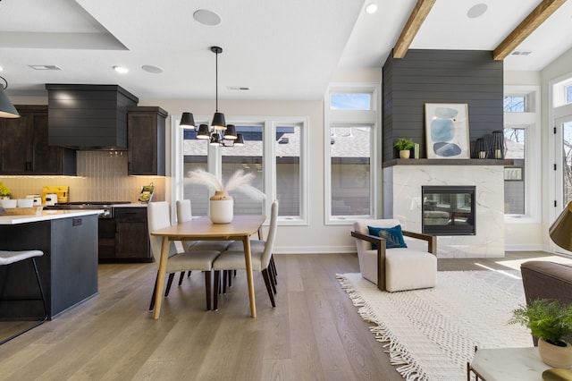 interior space featuring hardwood / wood-style floors, beamed ceiling, an inviting chandelier, and a fireplace