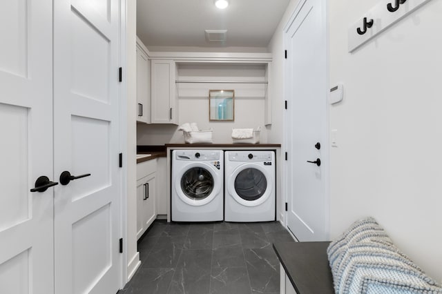 washroom featuring dark tile patterned flooring, cabinets, and independent washer and dryer