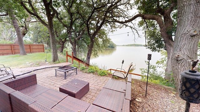 view of patio with a water view and fence