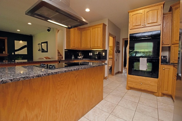 kitchen featuring under cabinet range hood, dark stone counters, light tile patterned floors, and black appliances