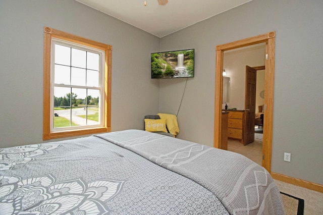 bedroom with light carpet and connected bathroom