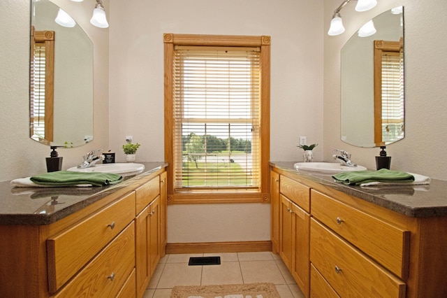 bathroom featuring a sink, two vanities, and tile patterned floors
