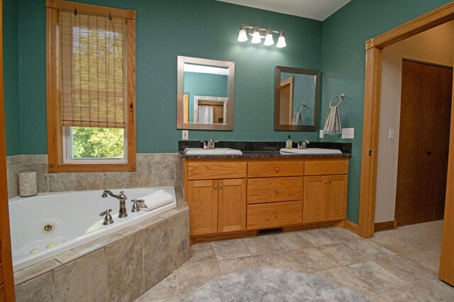 full bath featuring a jetted tub, a sink, and double vanity