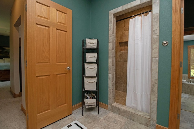 full bathroom featuring baseboards and a tile shower