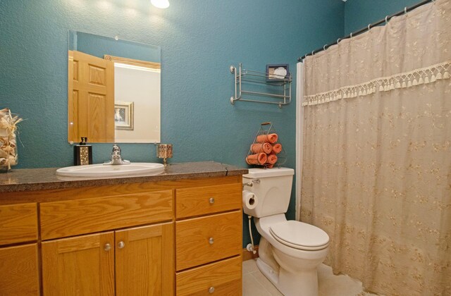 full bath with vanity, a textured wall, toilet, and curtained shower