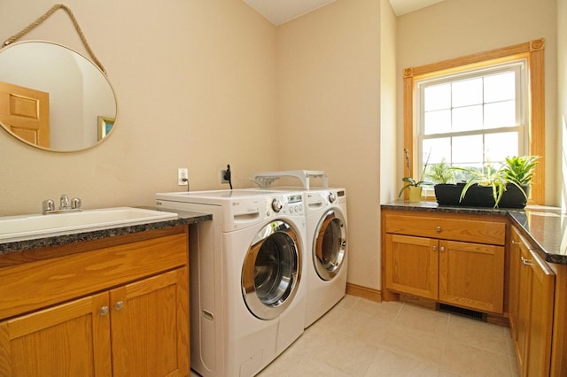 clothes washing area with visible vents, washing machine and dryer, cabinet space, light tile patterned floors, and a sink