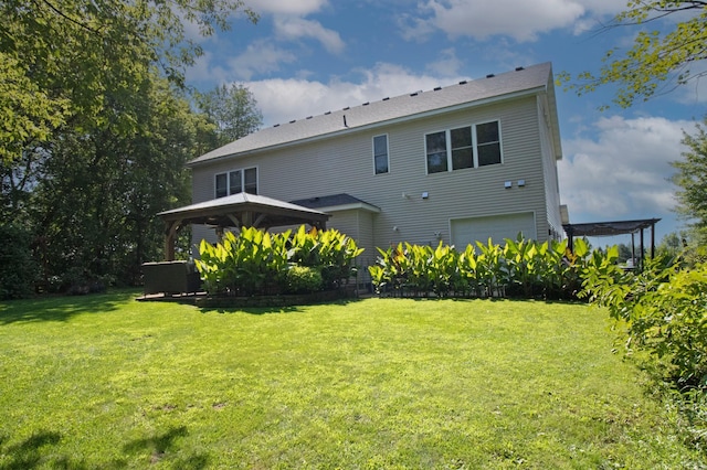 back of property with a lawn, a gazebo, and an attached garage