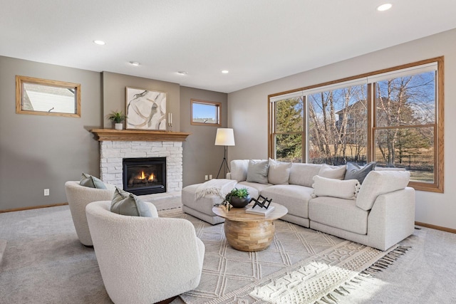 living area featuring light carpet, recessed lighting, a fireplace, and baseboards