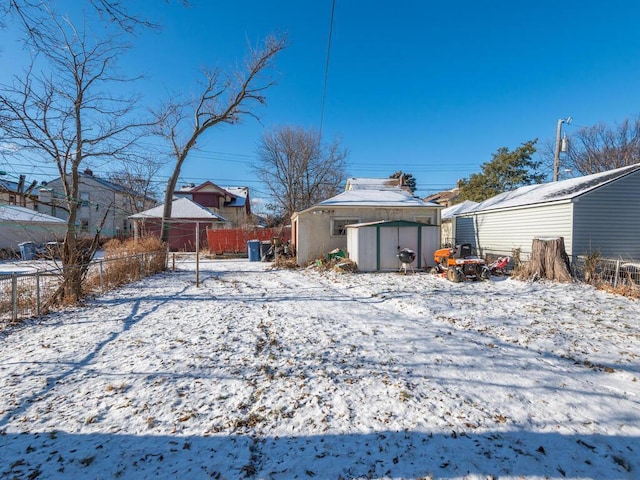 yard covered in snow with a storage unit