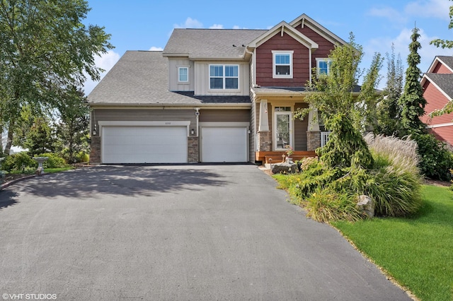 craftsman-style house with stone siding, aphalt driveway, and board and batten siding