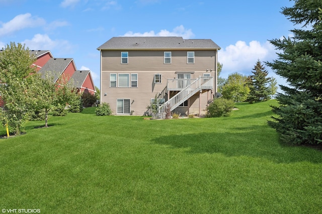 rear view of property with stairway, a lawn, and a wooden deck