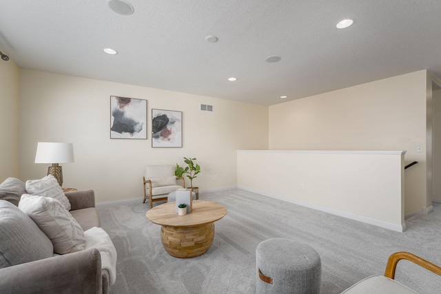 living area featuring light colored carpet, visible vents, baseboards, and recessed lighting