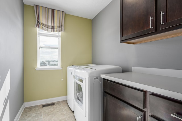 washroom with light tile patterned floors, cabinet space, visible vents, independent washer and dryer, and baseboards