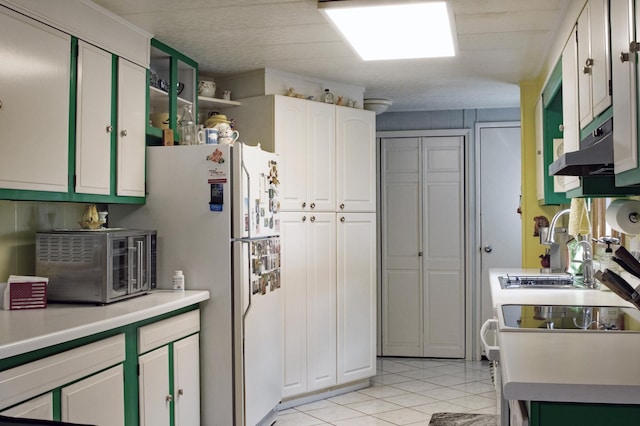 10873 69th Ave N, Maple Grove, MN 55369 - kitchen featuring freestanding refrigerator, light tile patterned floors, light countertops, white cabinets, and under cabinet range hood
