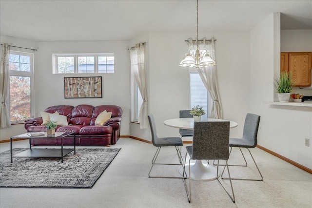 carpeted dining area featuring a notable chandelier