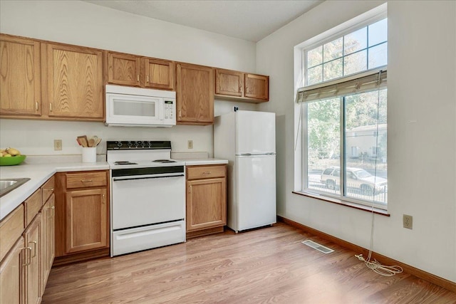 1229 Clarence St, Saint Paul, MN 55106 - kitchen featuring white appliances, light wood-style floors, light countertops, and brown cabinetry