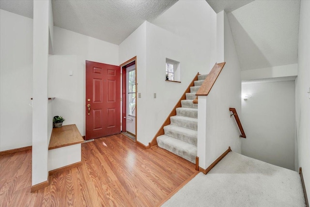 1229 Clarence St, Saint Paul, MN 55106 - foyer entrance with wood finished floors, baseboards, stairway, and a textured ceiling