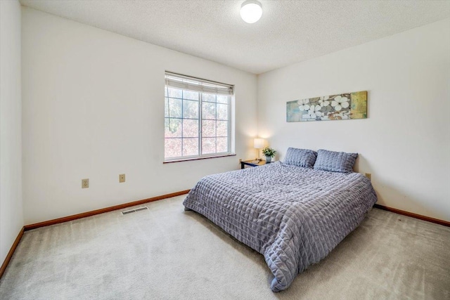 bedroom featuring carpet and a textured ceiling