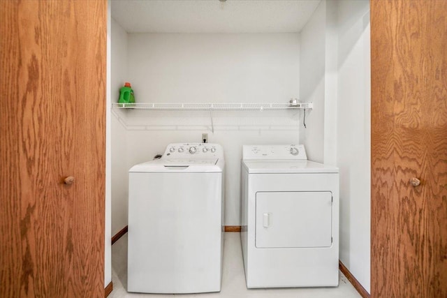 laundry room with a textured ceiling and washer and clothes dryer