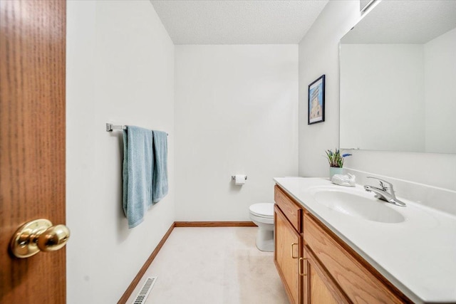 bathroom featuring vanity, a textured ceiling, and toilet