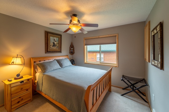 bedroom featuring ceiling fan, light carpet, and a textured ceiling