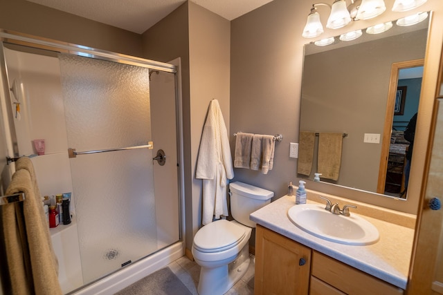 bathroom featuring vanity, toilet, a shower with shower door, and tile patterned flooring