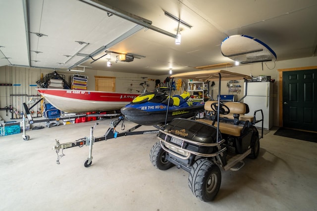 garage with a garage door opener and white fridge