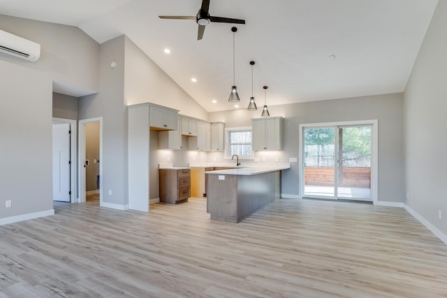 kitchen with pendant lighting, light hardwood / wood-style floors, a center island, high vaulted ceiling, and ceiling fan