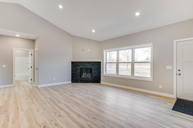 unfurnished living room with light hardwood / wood-style floors, a fireplace, and vaulted ceiling