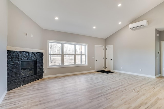 unfurnished living room with a stone fireplace, light hardwood / wood-style flooring, high vaulted ceiling, and an AC wall unit