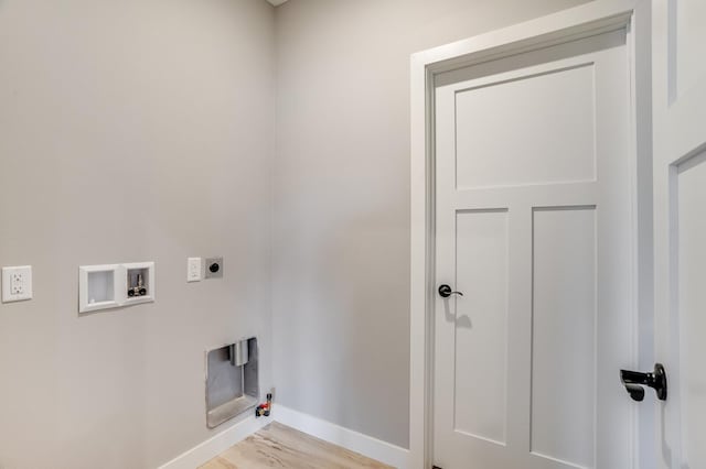 washroom with washer hookup, hookup for an electric dryer, light hardwood / wood-style floors, and gas dryer hookup