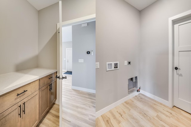 laundry area with hookup for an electric dryer, hookup for a gas dryer, light hardwood / wood-style floors, and hookup for a washing machine