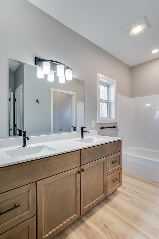 bathroom featuring hardwood / wood-style flooring, vanity, and a washtub