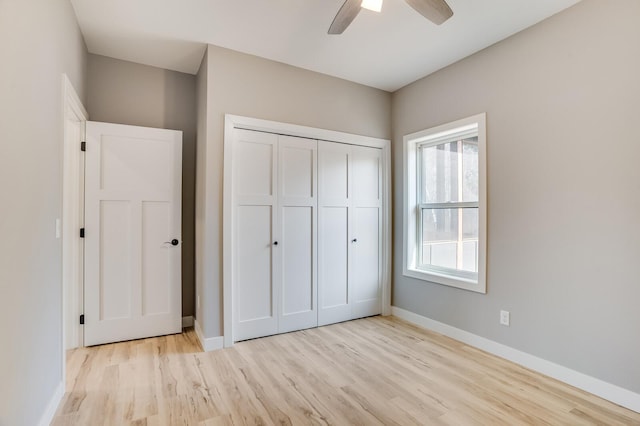 unfurnished bedroom featuring ceiling fan, light hardwood / wood-style flooring, and a closet