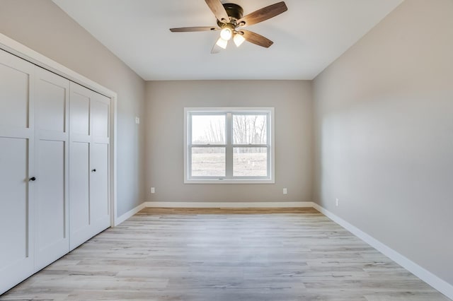 unfurnished bedroom featuring a closet, light hardwood / wood-style floors, and ceiling fan