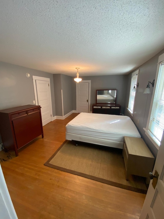 bedroom featuring wood-type flooring and a textured ceiling