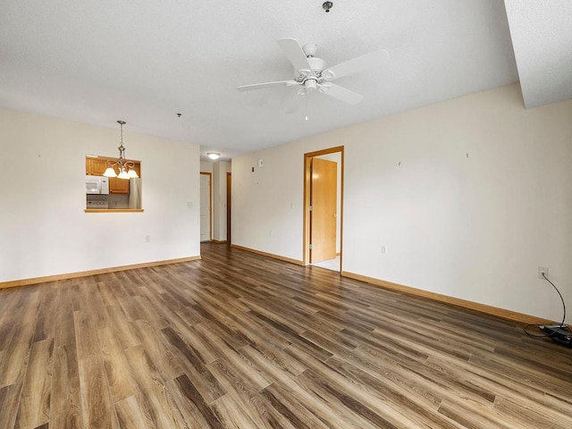 spare room featuring wood-type flooring and ceiling fan with notable chandelier