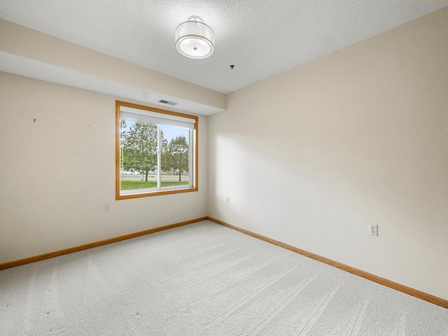 unfurnished room featuring carpet flooring and a textured ceiling