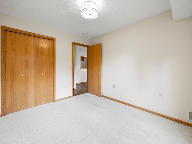 unfurnished bedroom with a closet, carpet floors, and a textured ceiling