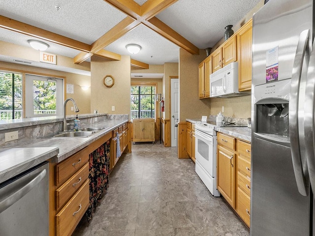 kitchen featuring coffered ceiling, a textured ceiling, stainless steel appliances, sink, and beamed ceiling