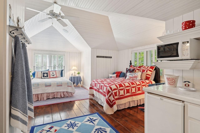 bedroom featuring dark hardwood / wood-style flooring, fridge, ceiling fan, and wooden walls