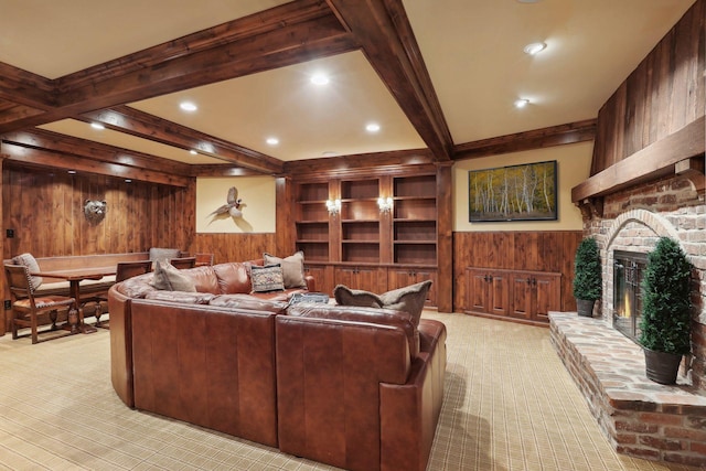 carpeted living room featuring beamed ceiling, a brick fireplace, and wooden walls