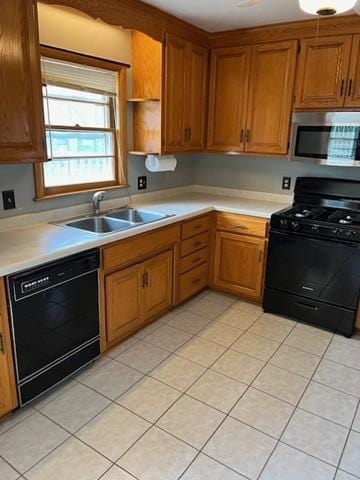 kitchen with black appliances, sink, and light tile patterned floors