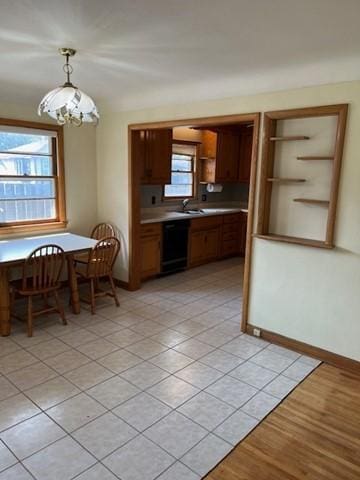 kitchen with hanging light fixtures, dishwasher, light tile patterned flooring, and a healthy amount of sunlight