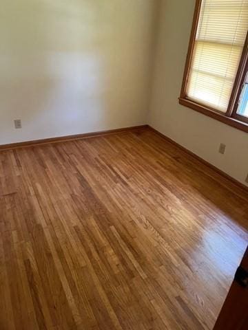 unfurnished room with hardwood / wood-style flooring