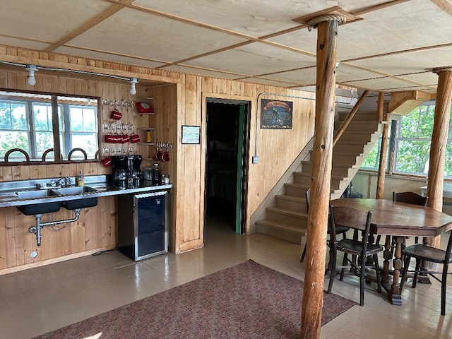 7155 Oak Narrows Rd, Greenwood Twp, MN 55723 - kitchen featuring wine cooler, wood walls, and a sink
