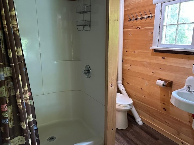 7155 Oak Narrows Rd, Greenwood Twp, MN 55723 - bathroom featuring a stall shower, wood finished floors, toilet, and wood walls