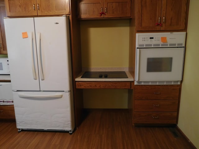 kitchen with dark hardwood / wood-style flooring and white appliances